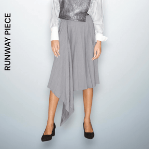 Model Anastasia, 183 cm, wearing a mid-length asymmetrical pleated gray skirt with an irregular hemline. A signature piece from Unfolloworld’s CROSSROADS runway show, "From Paris to Limassol."